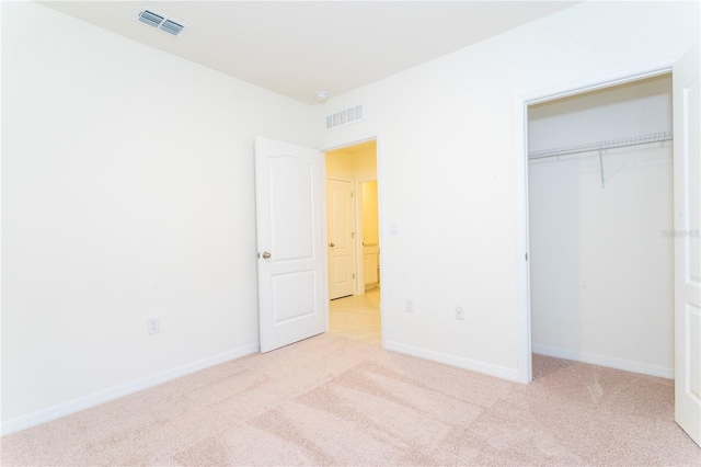 unfurnished bedroom with a closet and light carpet