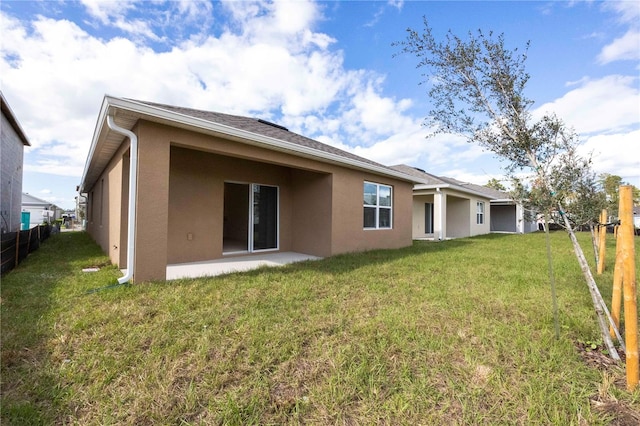 rear view of house with a patio and a yard