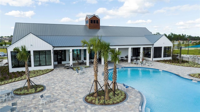 view of swimming pool with a patio area and a sunroom