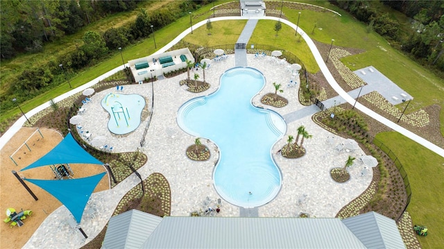 view of pool with a patio area and a yard