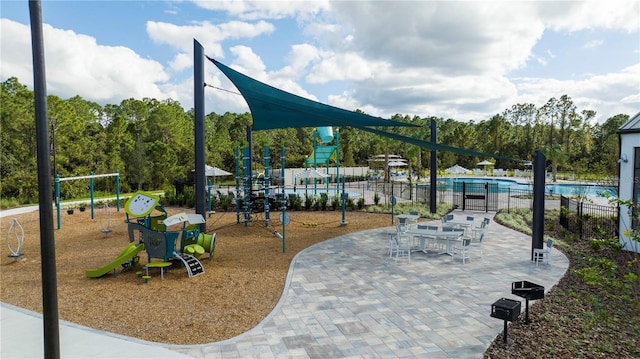 exterior space featuring a swimming pool and a playground