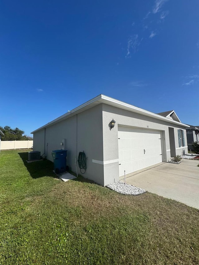 view of property exterior featuring a lawn, cooling unit, and a garage