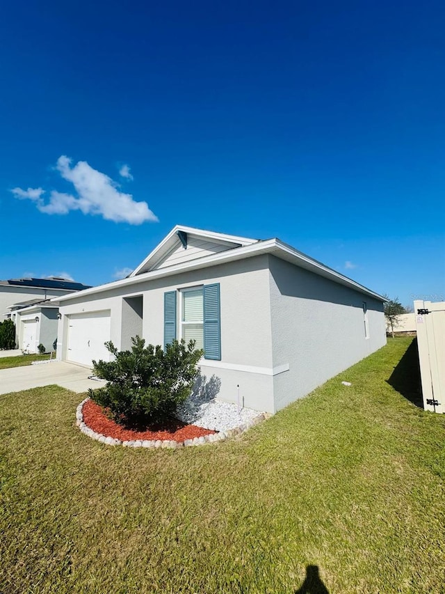 view of side of home featuring a yard and a garage