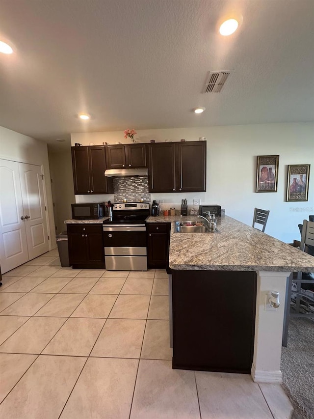 kitchen with light stone counters, kitchen peninsula, stainless steel electric stove, light tile patterned floors, and sink