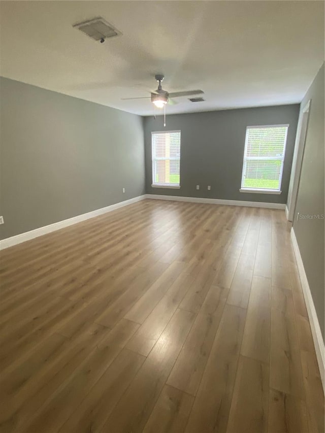 unfurnished room with hardwood / wood-style floors and ceiling fan