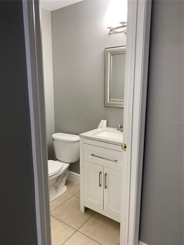 bathroom featuring toilet, vanity, and tile patterned floors