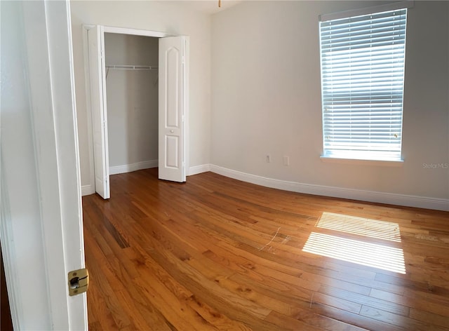 unfurnished bedroom with hardwood / wood-style flooring and a closet