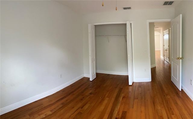 unfurnished bedroom featuring dark hardwood / wood-style floors and a closet