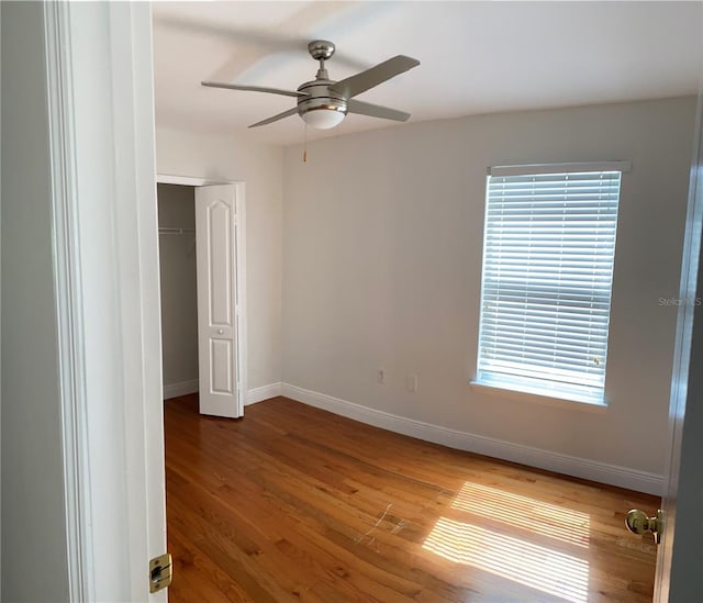 unfurnished bedroom with ceiling fan, a closet, and wood-type flooring