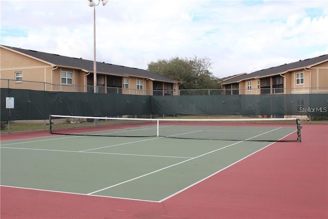 view of tennis court with basketball hoop