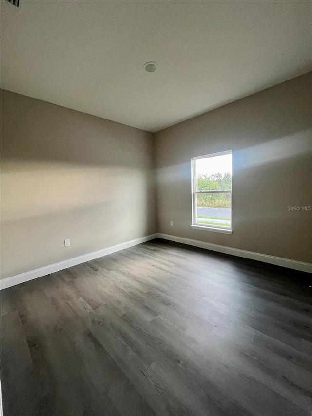 unfurnished room featuring dark wood-type flooring