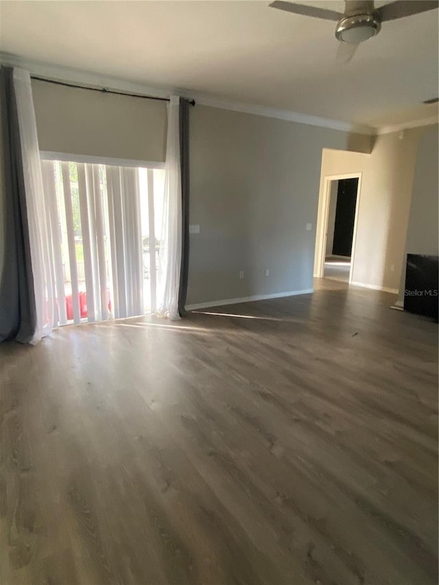 unfurnished living room featuring dark wood-type flooring, ceiling fan, and crown molding