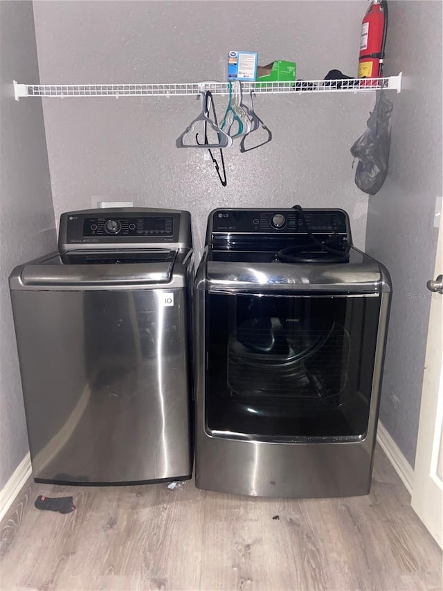 laundry area with separate washer and dryer and wood-type flooring