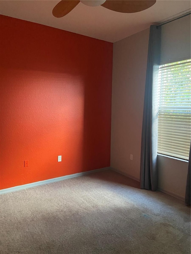 carpeted spare room with ceiling fan