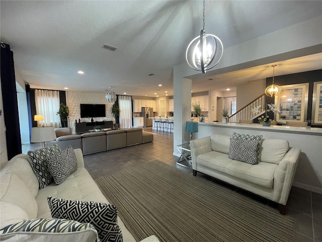 tiled living room featuring a textured ceiling and an inviting chandelier