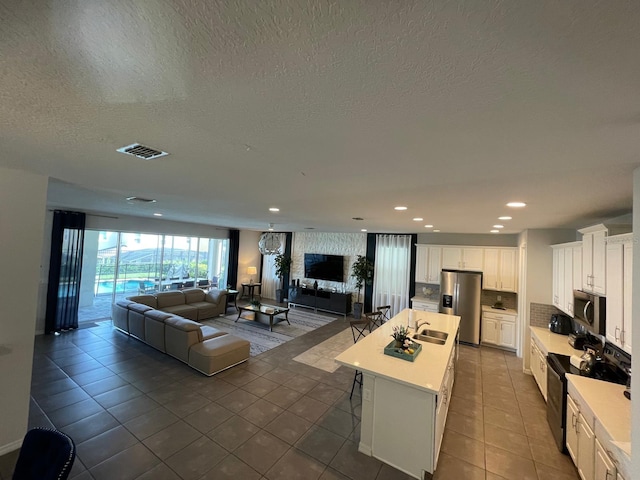 tiled living room featuring sink and a textured ceiling