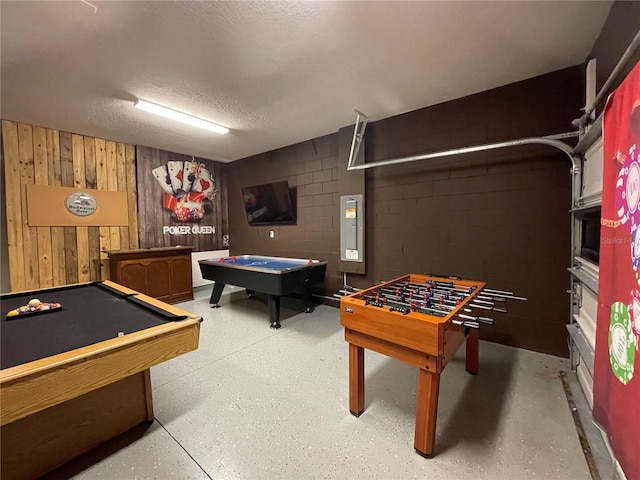 rec room featuring wood walls, a textured ceiling, and pool table