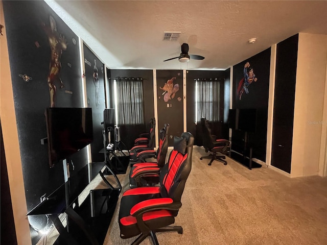 home office featuring a textured ceiling, carpet flooring, and ceiling fan