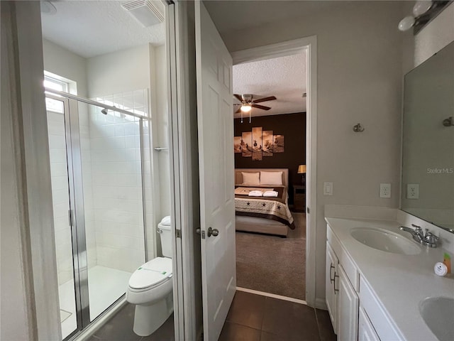 bathroom featuring ceiling fan, a textured ceiling, vanity, tile patterned floors, and toilet