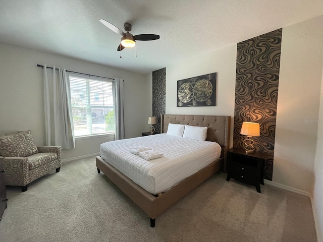 bedroom featuring ceiling fan, a textured ceiling, and light colored carpet