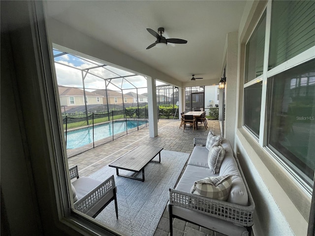 view of patio featuring outdoor lounge area, glass enclosure, and ceiling fan