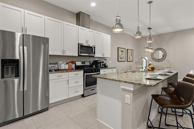 kitchen with dark stone counters, sink, an island with sink, appliances with stainless steel finishes, and white cabinetry