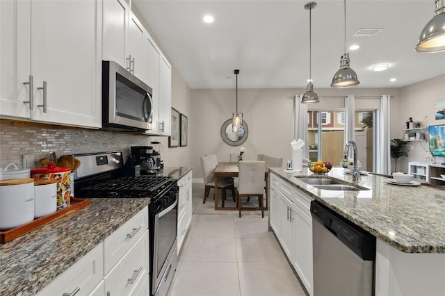 kitchen featuring sink, white cabinetry, stainless steel appliances, and hanging light fixtures