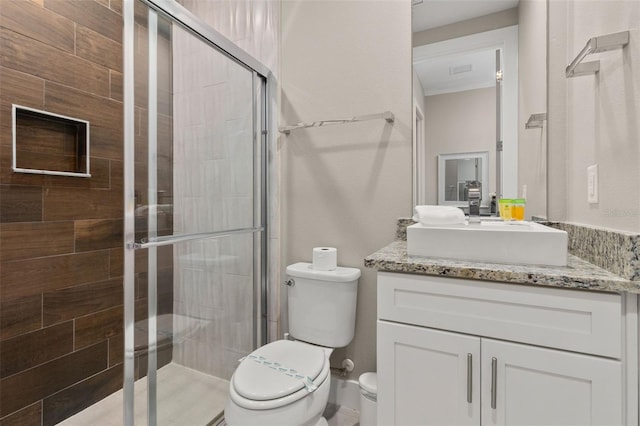 bathroom with vanity, toilet, and a shower with shower door