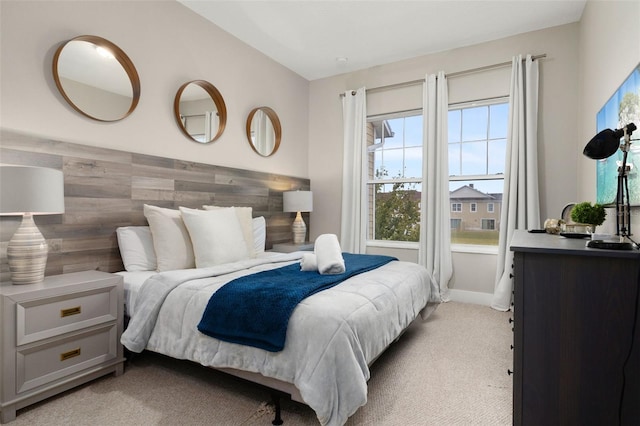 bedroom featuring light colored carpet and wood walls