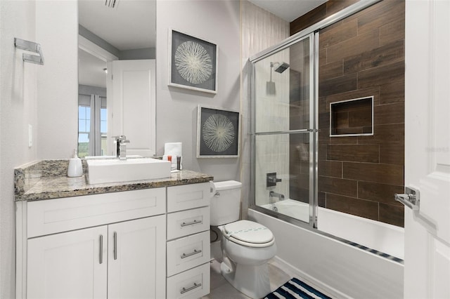 full bathroom with vanity, bath / shower combo with glass door, and toilet