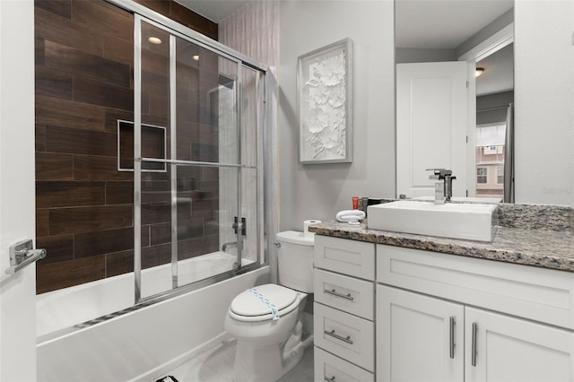 full bathroom featuring vanity, toilet, and bath / shower combo with glass door