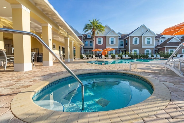 view of swimming pool featuring a community hot tub and a patio