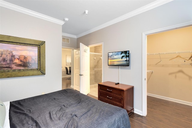 bedroom featuring a spacious closet, a closet, dark wood-type flooring, and ornamental molding