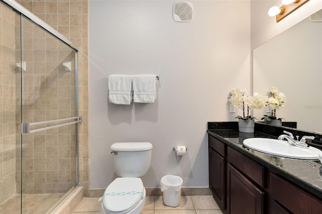 bathroom featuring tile patterned flooring, vanity, toilet, and walk in shower