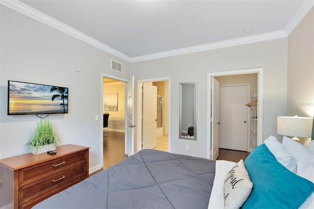 bedroom featuring light hardwood / wood-style flooring, ensuite bath, a closet, and crown molding