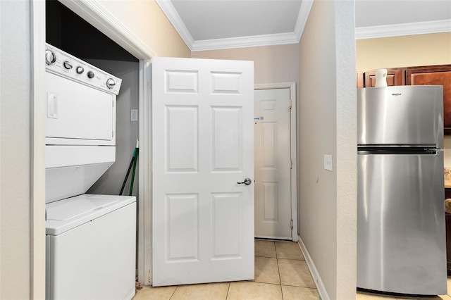 laundry room featuring stacked washing maching and dryer, crown molding, and light tile patterned floors