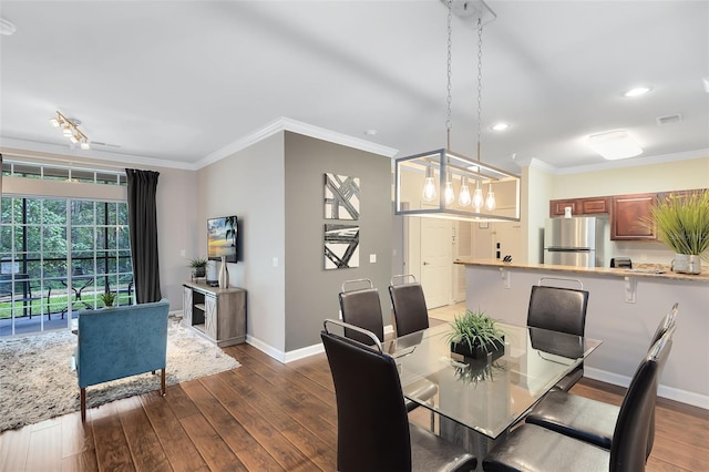 dining area with dark hardwood / wood-style flooring, a notable chandelier, and ornamental molding