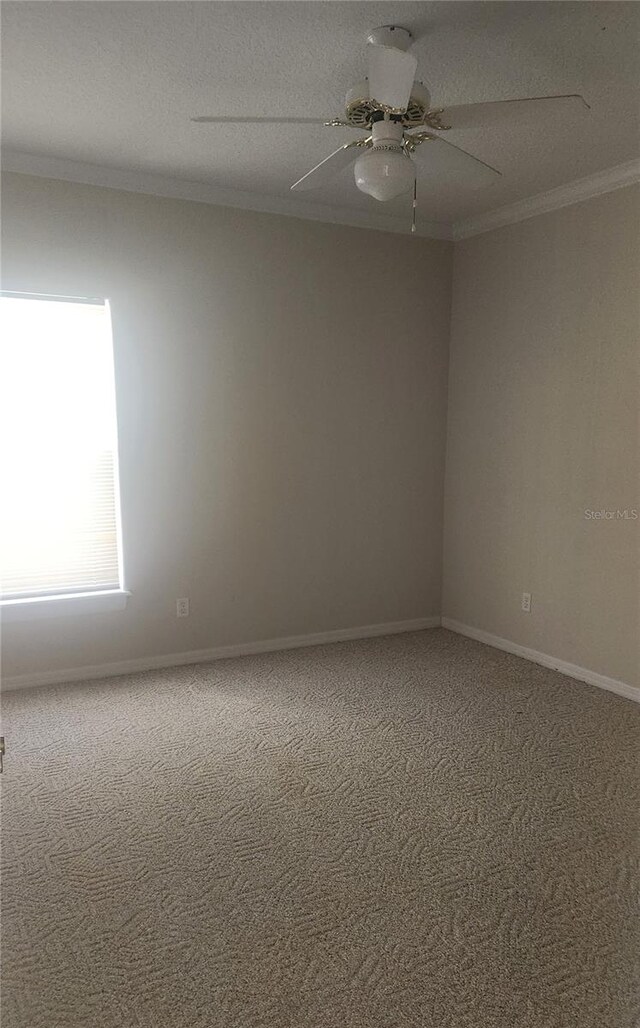 unfurnished room featuring carpet flooring, a textured ceiling, ceiling fan, and ornamental molding