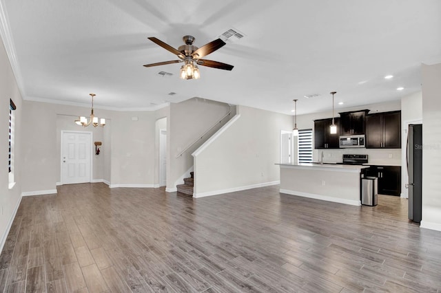 unfurnished living room featuring sink, hardwood / wood-style floors, ceiling fan with notable chandelier, and ornamental molding