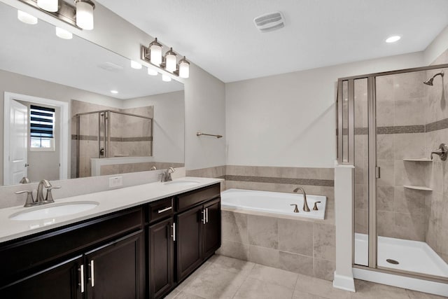 bathroom featuring tile patterned flooring, shower with separate bathtub, and vanity