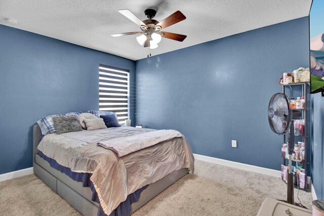 carpeted bedroom with ceiling fan and a textured ceiling