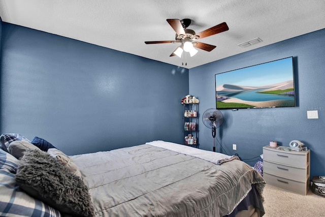 carpeted bedroom with a textured ceiling and ceiling fan