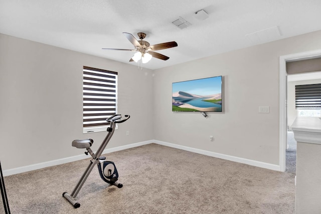 exercise area featuring ceiling fan and light colored carpet