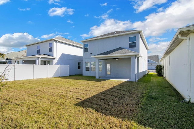 rear view of property featuring a patio area and a lawn