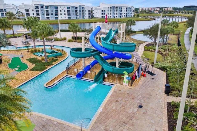 view of swimming pool featuring a playground, a water view, and a water slide