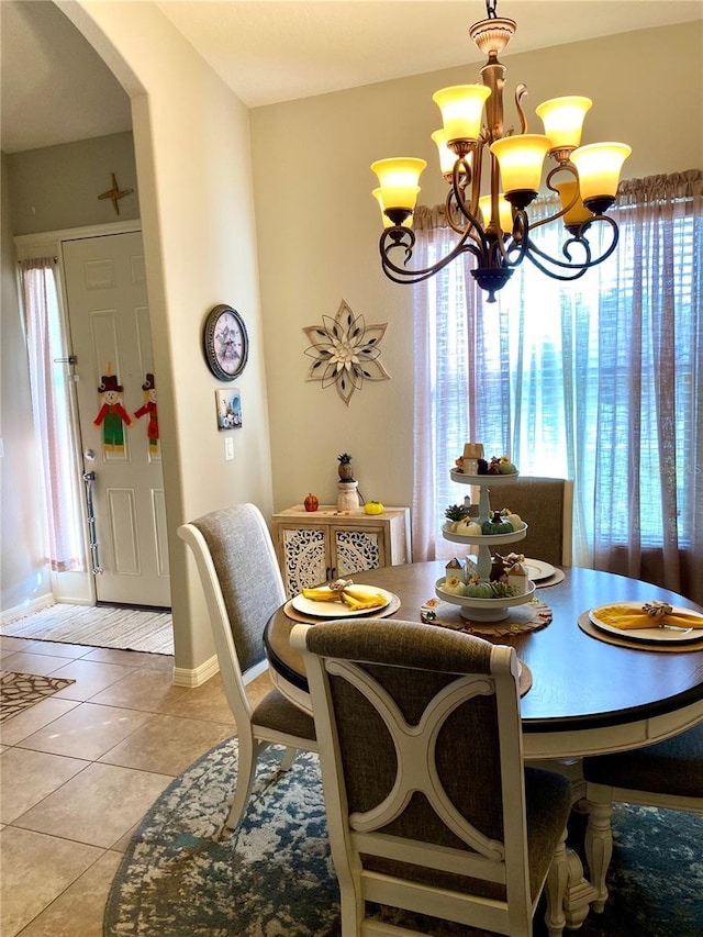 dining space with light tile patterned floors and a notable chandelier