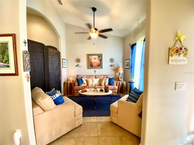 living room with ceiling fan, light tile patterned flooring, and vaulted ceiling