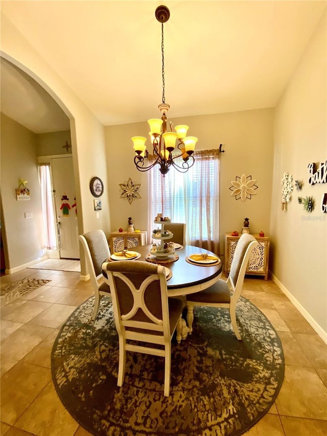 dining area featuring tile patterned floors and an inviting chandelier