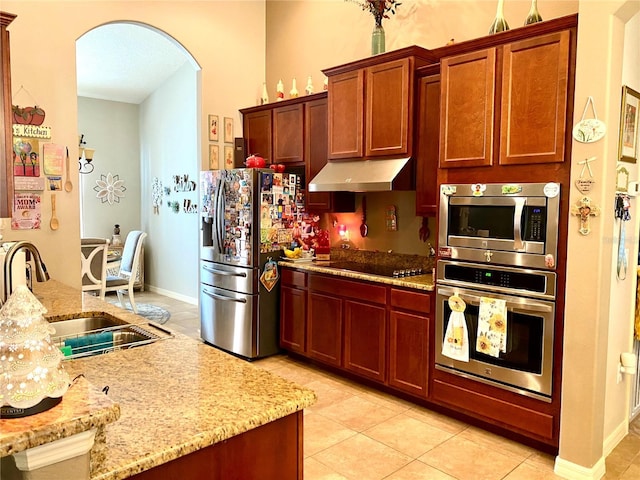 kitchen featuring light tile patterned flooring, light stone countertops, sink, and appliances with stainless steel finishes