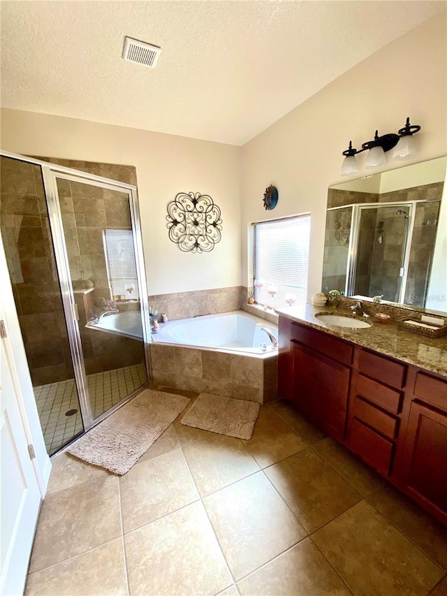 bathroom with tile patterned flooring, vanity, separate shower and tub, and a textured ceiling